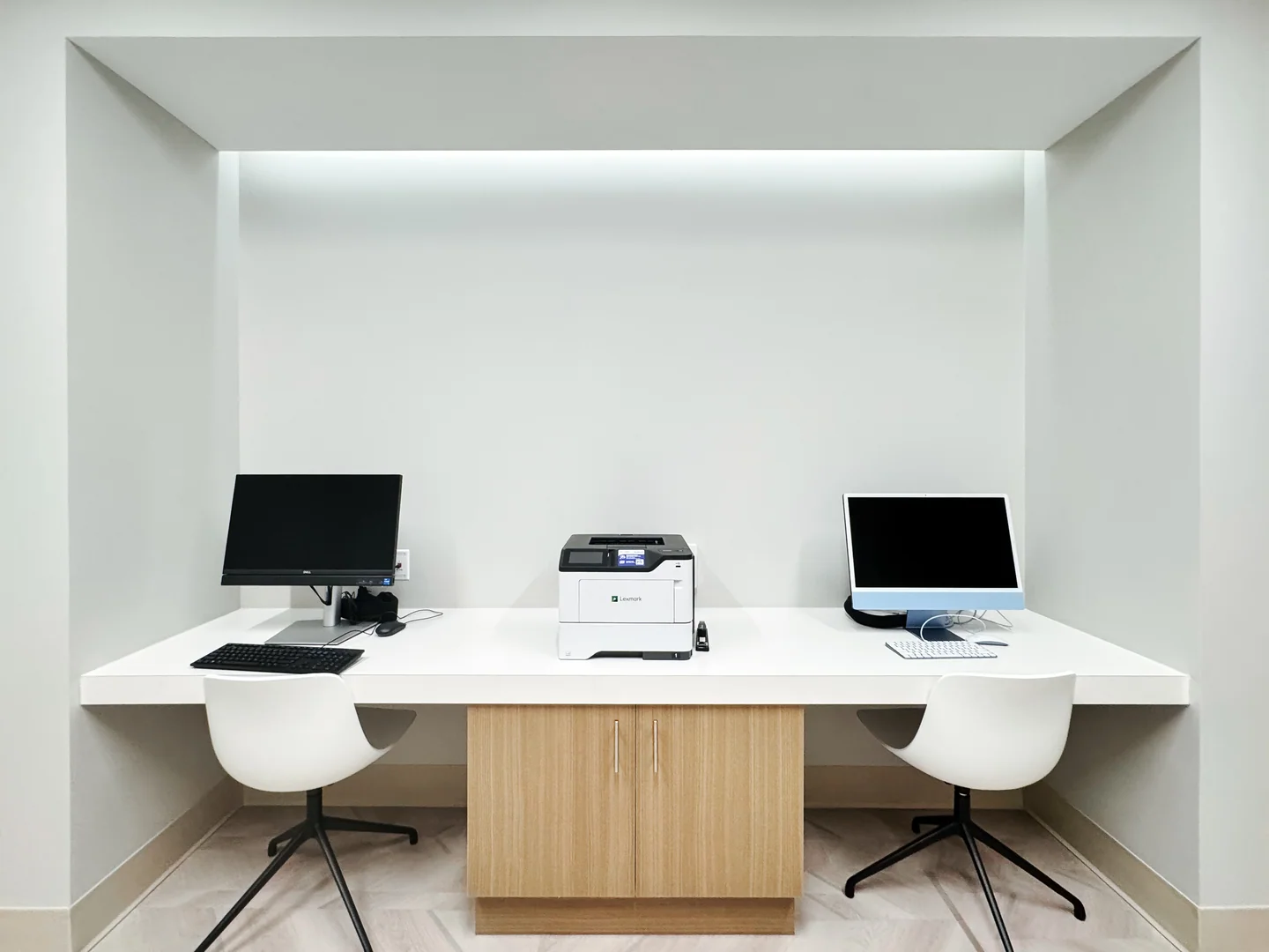 Two computers and a printer at a shared desk