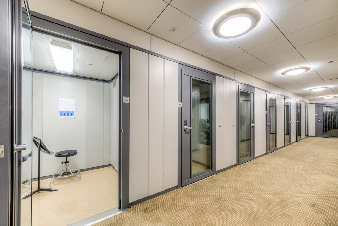 Individual music practice rooms with a music stand and stool