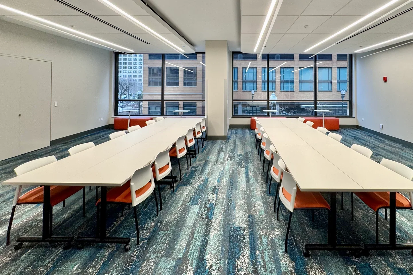 Bright community room with long tables and large windows